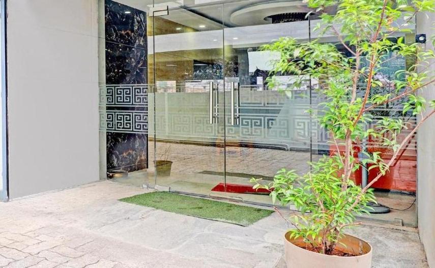 a glass door of a building with plants in front of it at Hotel Starlight Chennai near DLF,L&T,Miot,Tradecenter,Ramachandra medical coll in Chennai