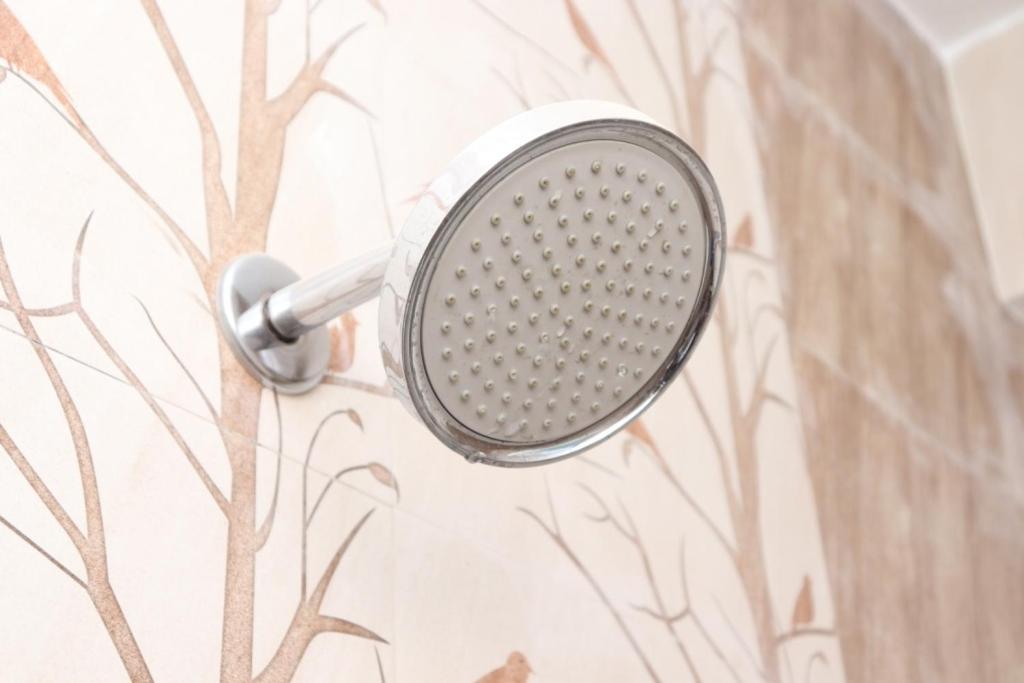 a shower head hanging on a wall with a tree mural at Hotel Starlight Chennai near DLF,L&T,Miot,Tradecenter,Ramachandra medical coll in Chennai