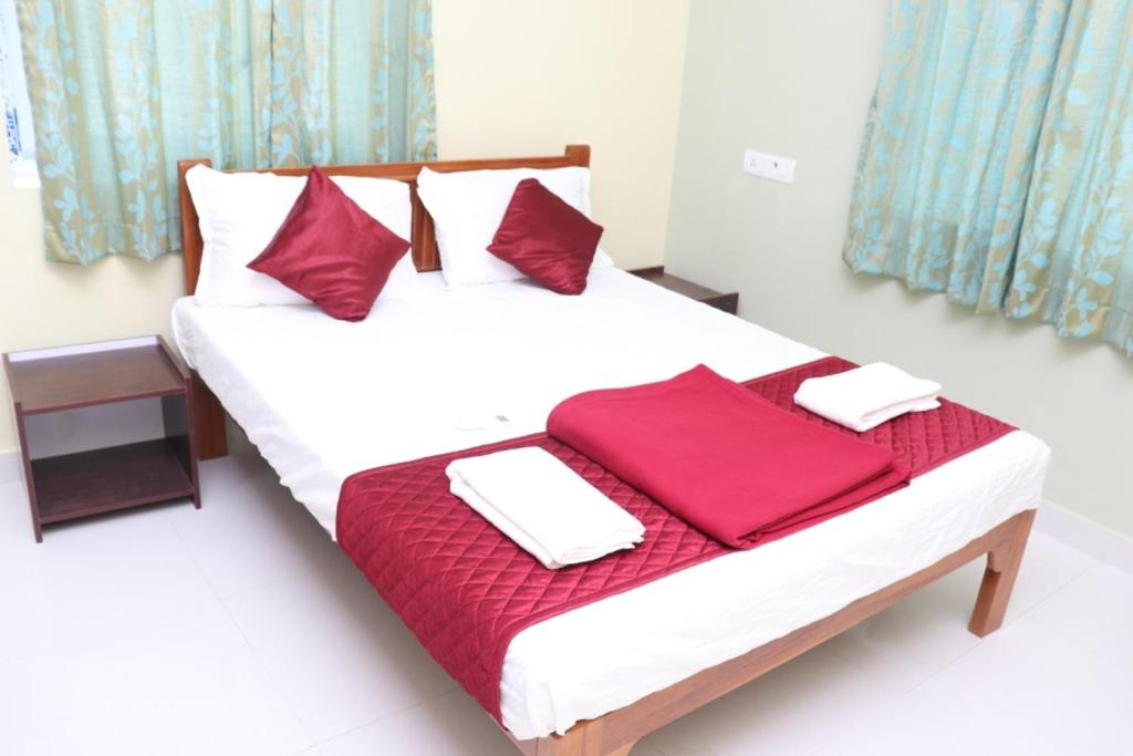 a bedroom with a bed with red pillows on it at Hotel Starlight Chennai near DLF,L&T,Miot,Tradecenter,Ramachandra medical coll in Chennai