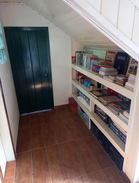 a room with a book shelf with books at A Cabana in Campos do Jordão