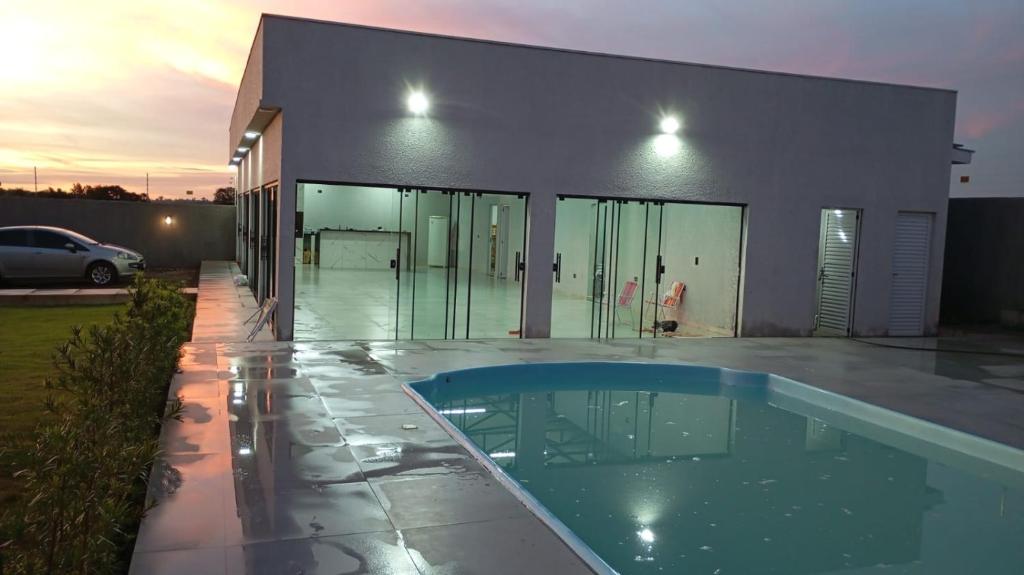 a house with a swimming pool in front of it at Chacara proximo as cataratas para 12 pessoas in Foz do Iguaçu