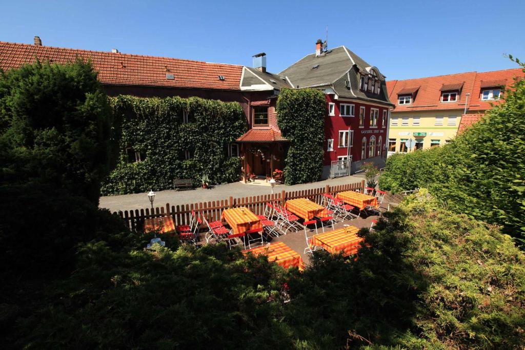un grupo de mesas y sillas frente a un edificio en Hotel Stadt Suhl, en Zella-Mehlis