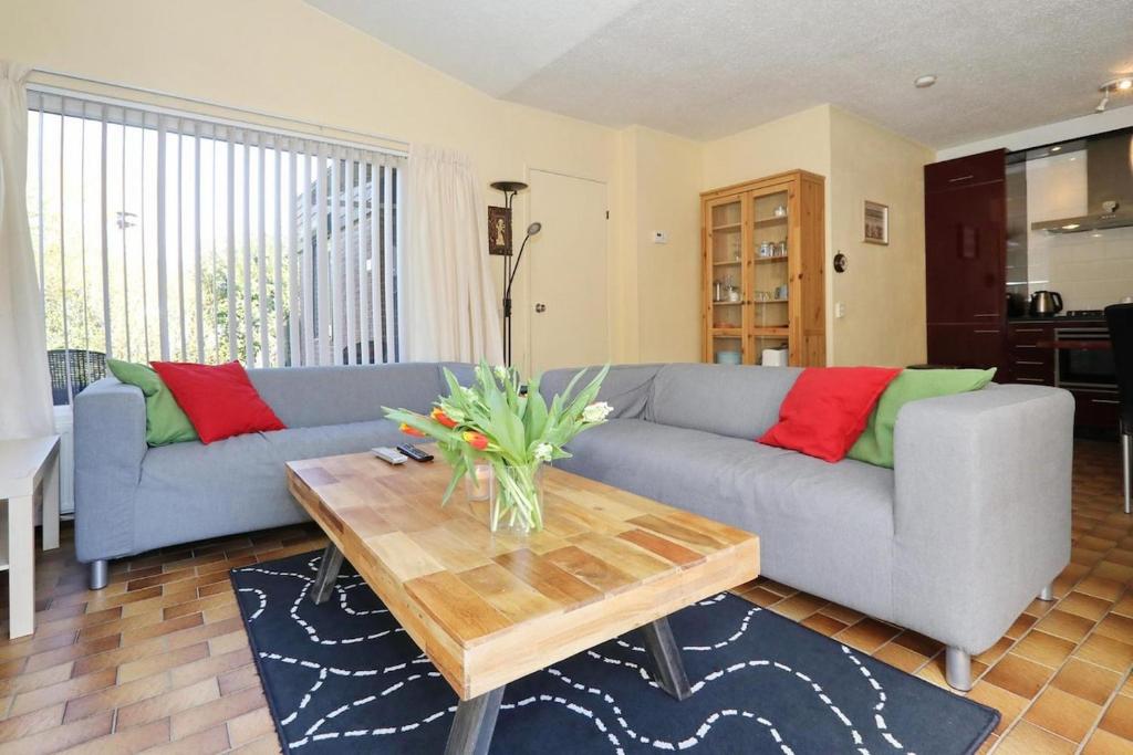 een woonkamer met een bank en een salontafel bij Holiday house Zeelust - 2 km from the beach in Noordwijkerhout