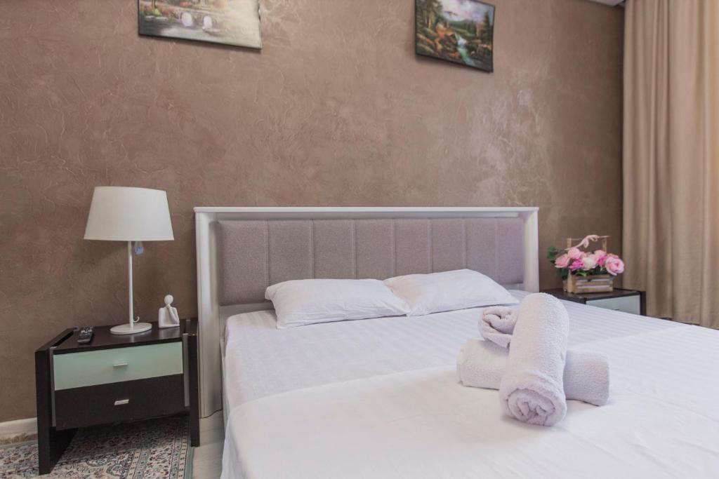 a bedroom with a white bed with towels on it at Двухкомнатная евро двушка в самом центре Алматы, 10 минут ходьбы до Арбата #23 in Almaty