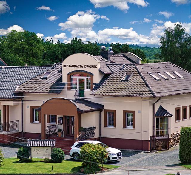 uma casa com um carro estacionado em frente em Dworek em Szonowice