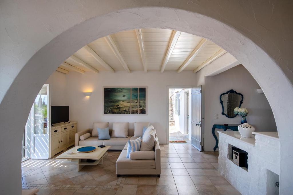 an archway in a living room with a couch and a fireplace at amazing sea view luxury villa for 6 guests in Ambelas