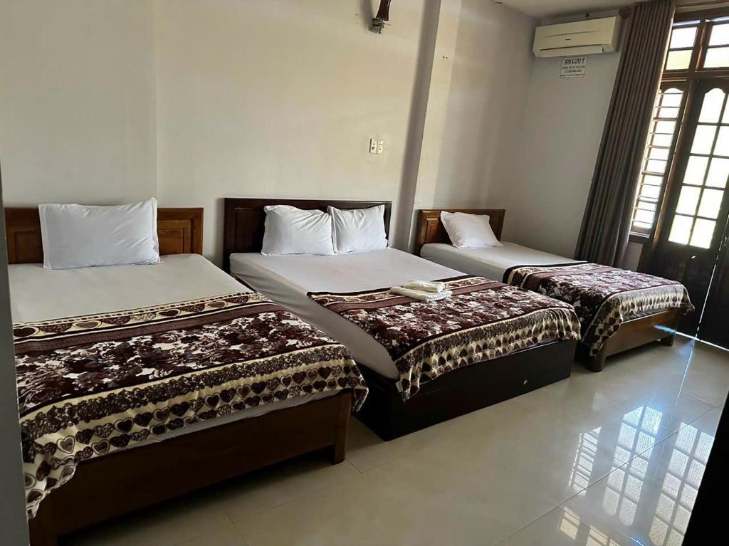 Un dormitorio con dos camas en una habitación. en Nhà nghỉ THANH HẰNG, en Hue
