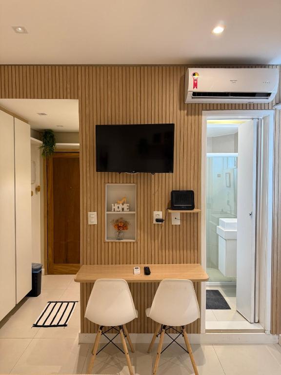 Hotel ACONCHEGANTE APARTAMENTO NO LEBLOn, a living room with a table and two chairs at ACONCHEGANTE APARTAMENTO NO LEBLOn in Rio de Janeiro