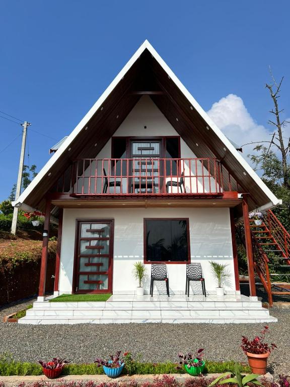 a house with two chairs and a balcony at Verdant peaks Homestay in Vagamon
