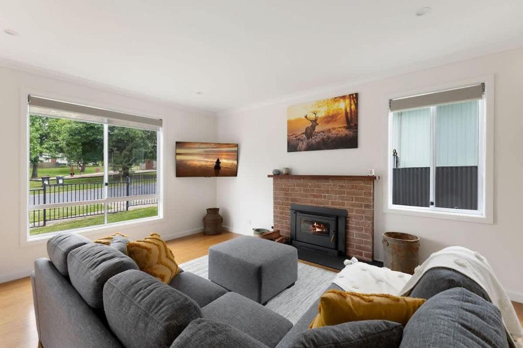 a living room with a couch and a fireplace at Lemon & Myrtle Cottage in Myrtleford