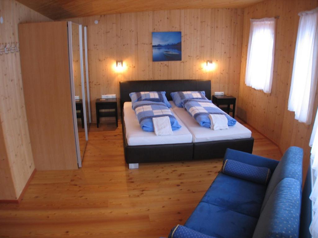 ein Schlafzimmer mit einem Bett mit blauen Kissen darauf in der Unterkunft Appartments Hilton in Altenmarkt im Pongau