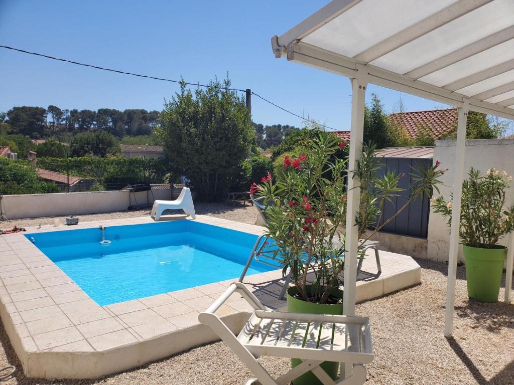 - une piscine avec une chaise et un parasol dans l'établissement Villa du canton vert, à Plan-de-Cuques