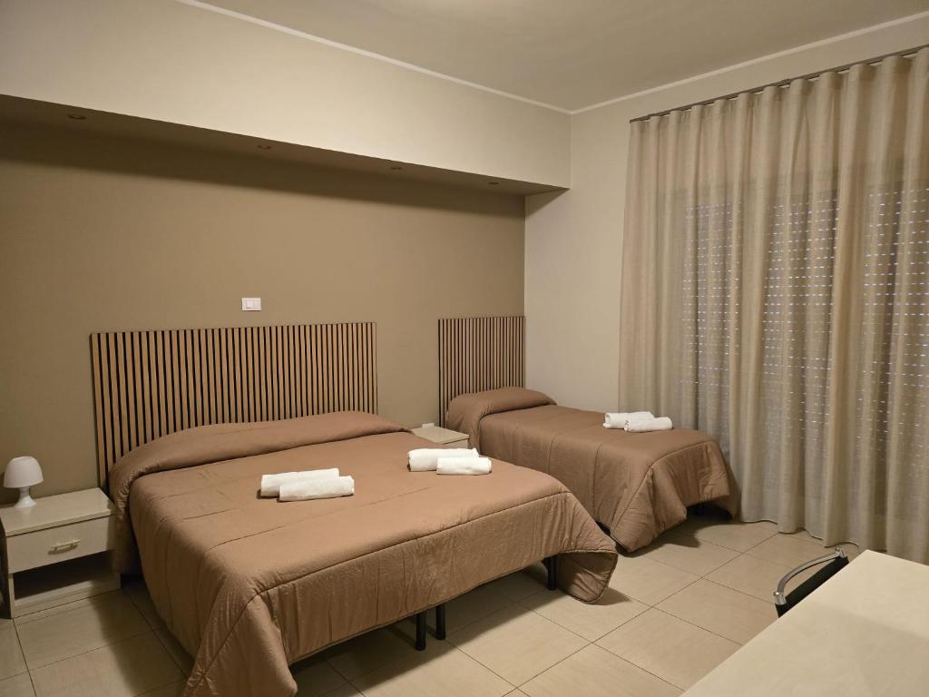 a bedroom with two beds with towels on them at Il Fiore di San Giovanni B&B in Milazzo