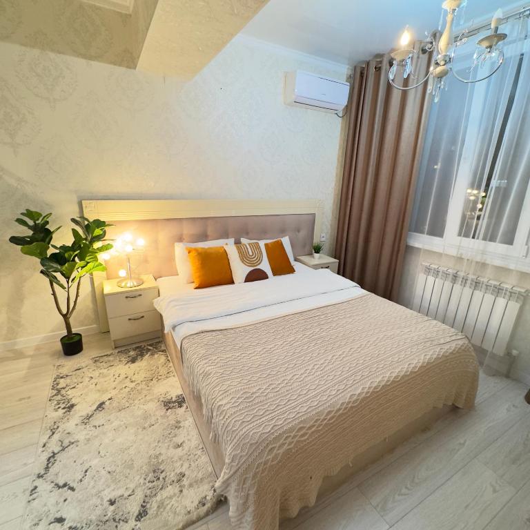 a bedroom with a large bed and a window at Urban Oasis 216 in Almaty