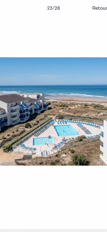 - une vue aérienne sur un complexe avec piscines et l'océan dans l'établissement Appartement bord de mer, à Lacanau