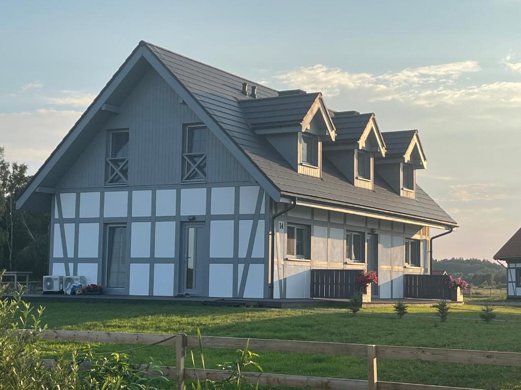 a large house with a gambrel roof at Słowiński Horyzont in Rowy