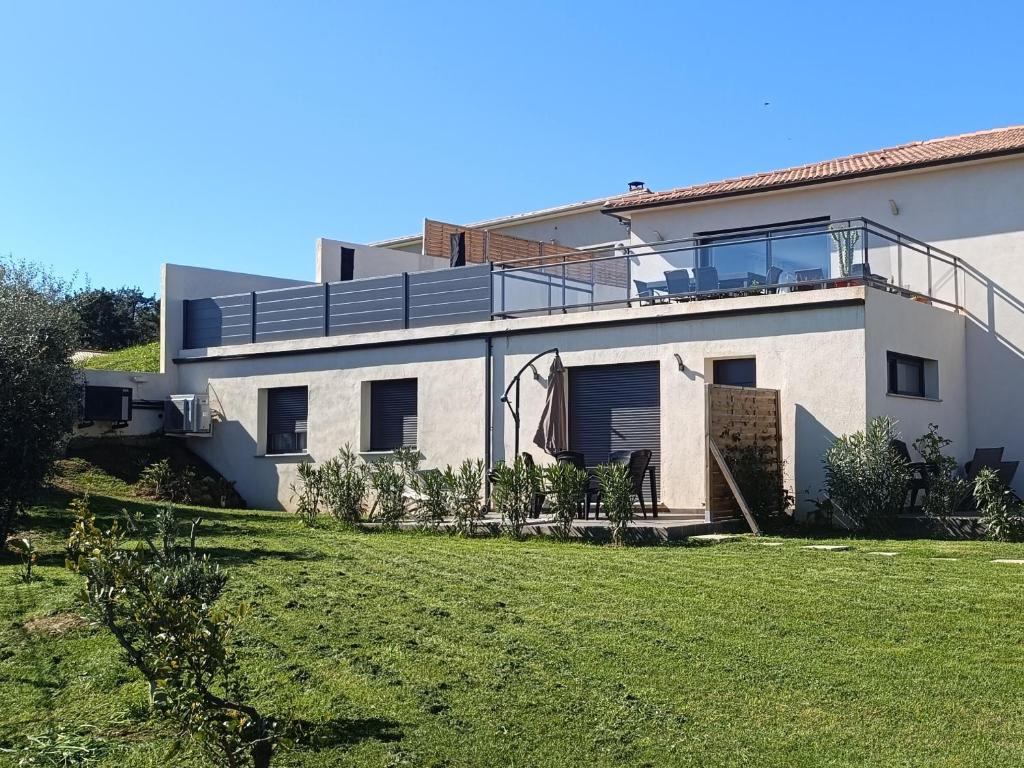 a white house with a lawn in front of it at Dume et Coco F2 55 M2 Vue mer in Taglio-Isolaccio