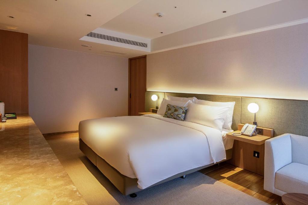 Postel nebo postele na pokoji v ubytování Kilin Hotel, JiaoXi