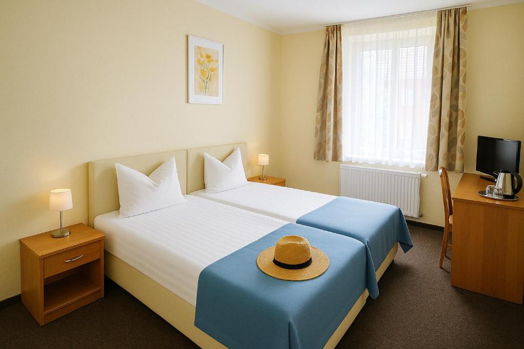 a hotel room with a bed with a hat on it at Nad brzegiem Bałtyku in Sarbinowo
