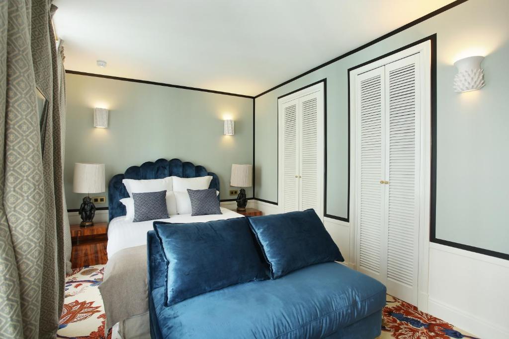 a bedroom with a bed and a blue couch at Makom Ferdinand Duval in Paris