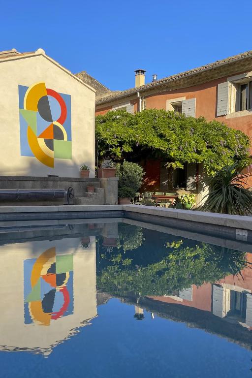 - une piscine avec des peintures sur le côté d'une maison dans l'établissement Maison d'hôtes Kazaart, à Robion