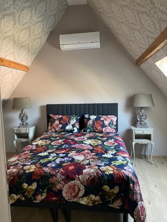 une chambre avec un lit avec une couette colorée dans l'établissement Au cœur de l'Alsace, à Turckheim