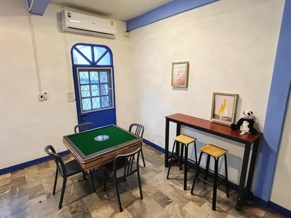 a room with a table and stools and a table and a table and chairs at 曼谷市中心大空间6卧室花园泳池别墅 in Bangkok