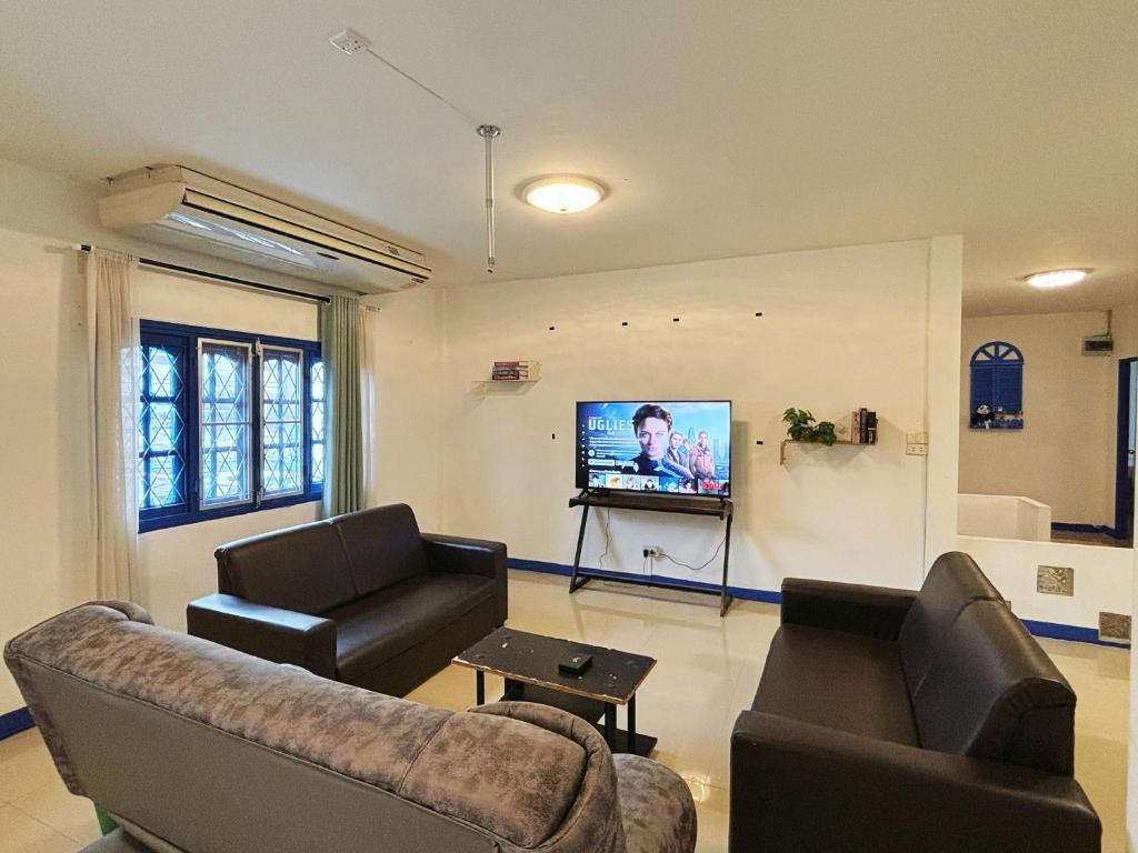 a living room with two couches and a flat screen tv at 曼谷市中心大空间6卧室花园泳池别墅 in Bangkok