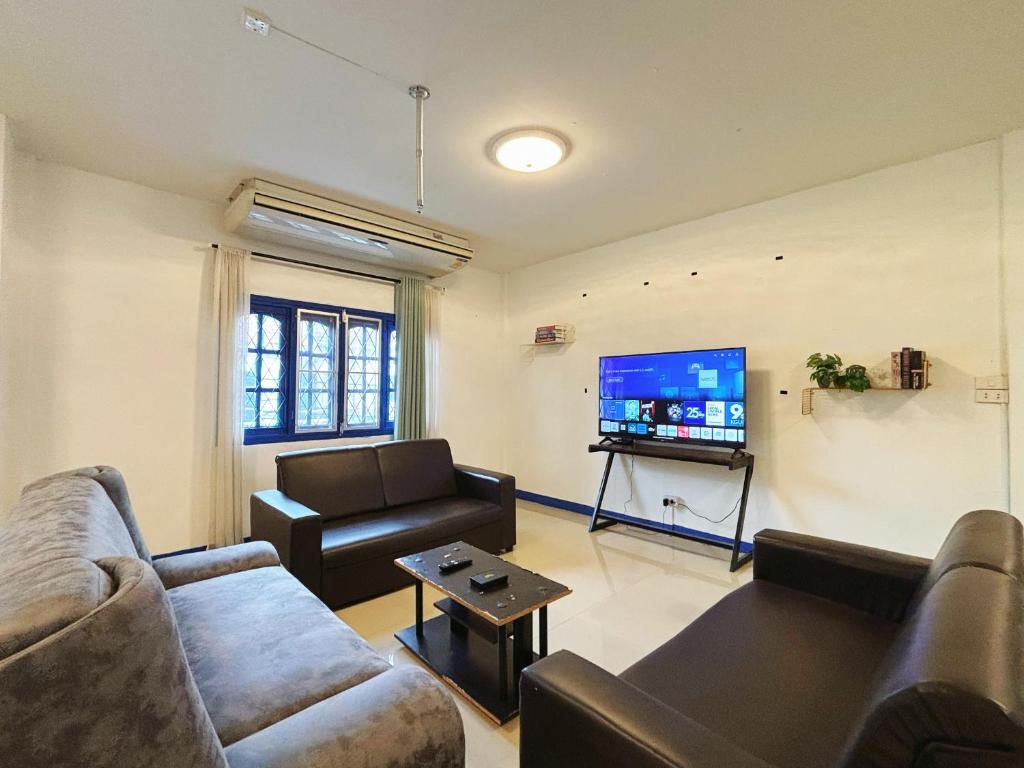 a living room with two couches and a flat screen tv at 曼谷市中心大空间6卧室花园泳池别墅 in Bangkok