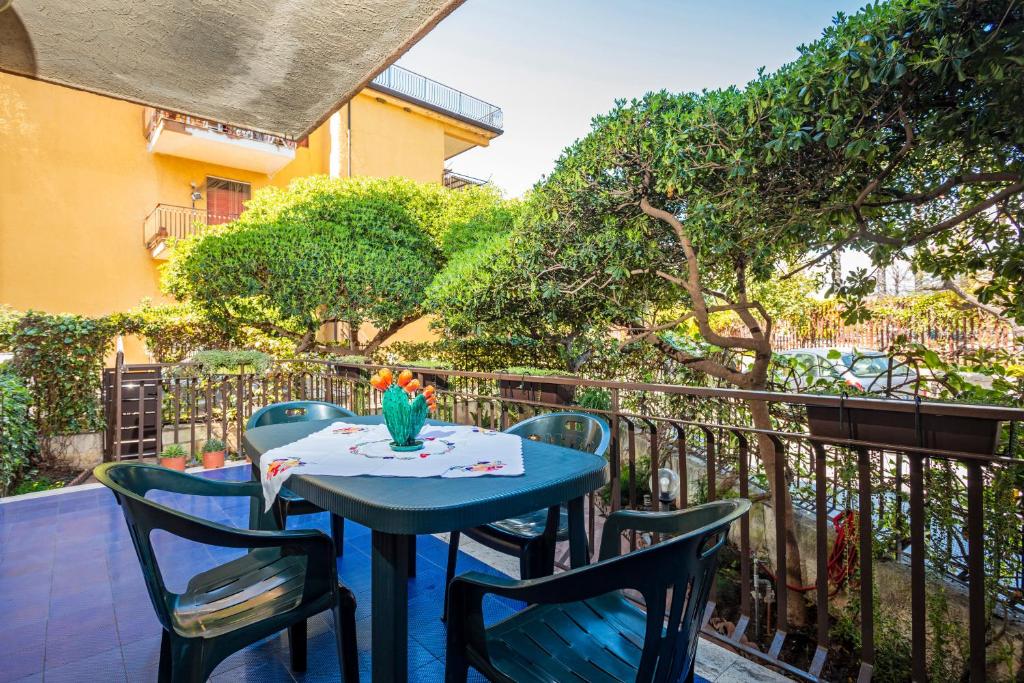 una mesa azul y sillas en el balcón en Casa Musa Giardini Naxos, en Giardini Naxos