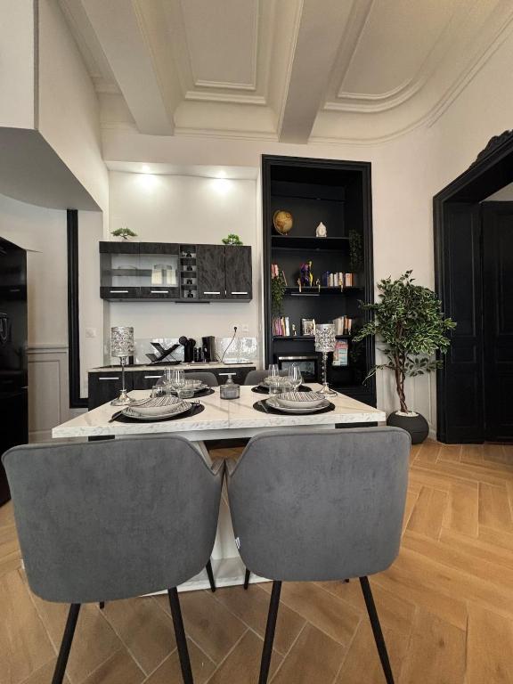 une cuisine avec une grande île et 2 chaises dans l'établissement Le petit boudoir de Beziers, à Béziers