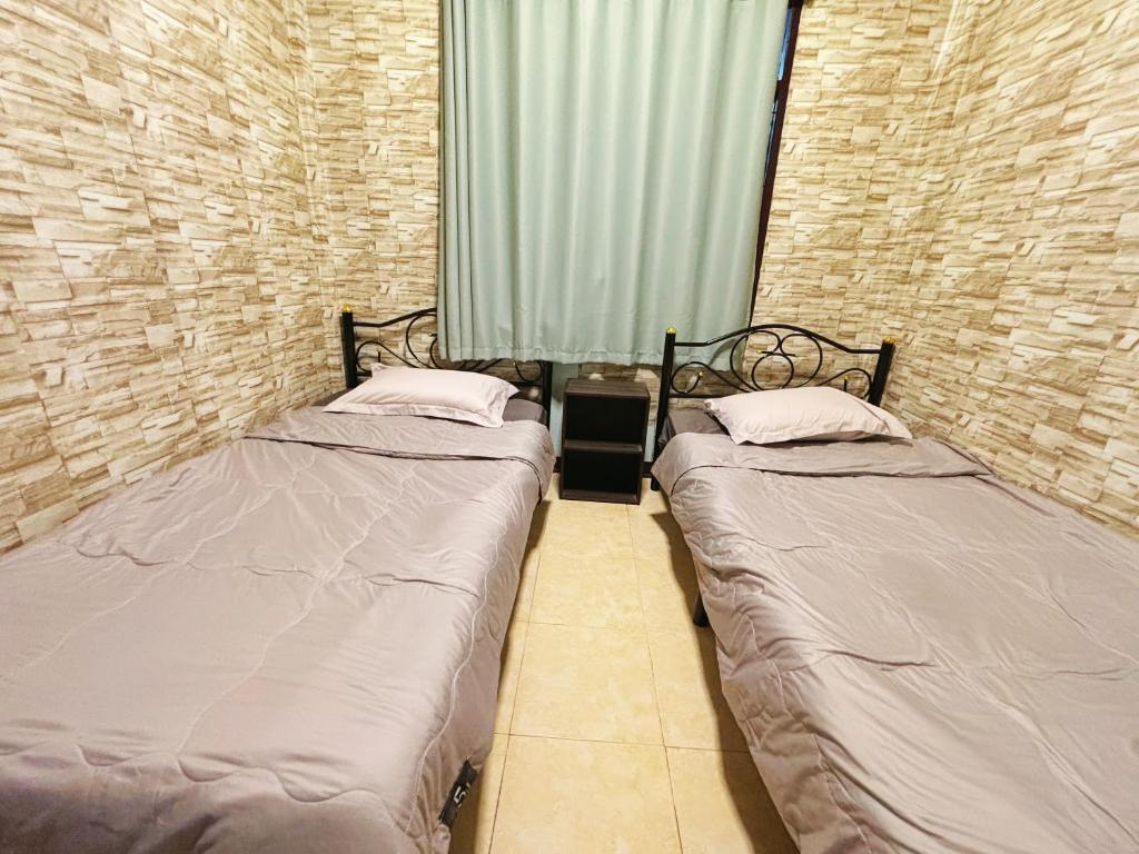 two twin beds in a room with a window at 曼谷市中心大空间6卧室花园泳池别墅 in Bangkok