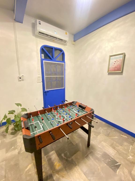 a foosball table in a room with a blue door at 曼谷市中心大空间6卧室花园泳池别墅 in Bangkok