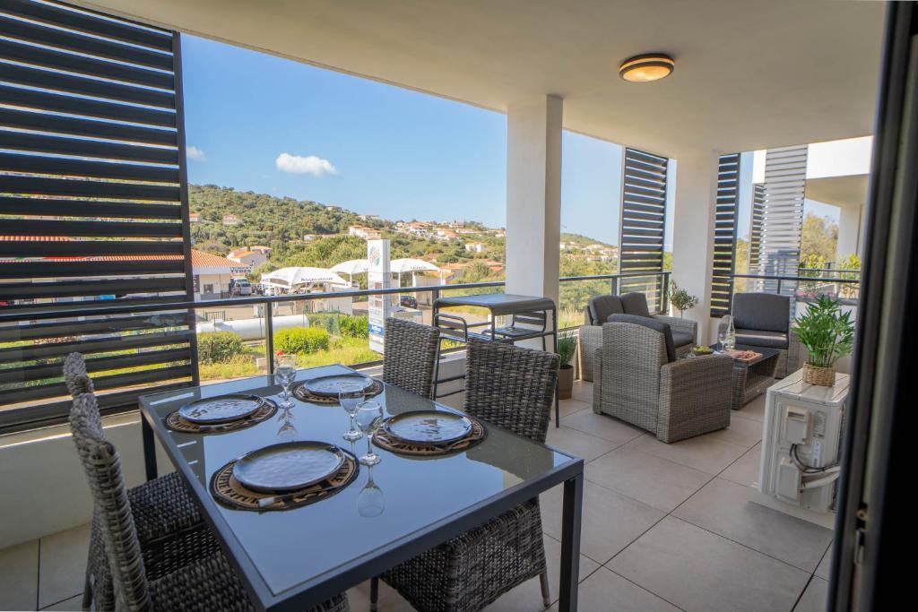 une salle à manger avec une table et des chaises sur un balcon dans l'établissement Charmant T2 proche centre ville et terrasse, à Propriano