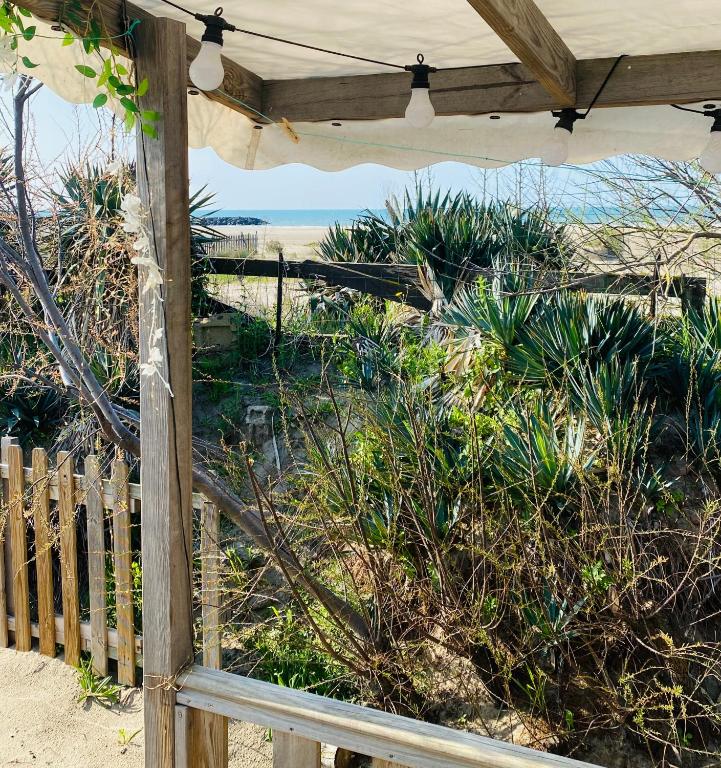 - une terrasse couverte avec un parasol et une vue sur la plage dans l'établissement Emplacement exceptionnel et rare sur la plage!, au Grau-dʼAgde