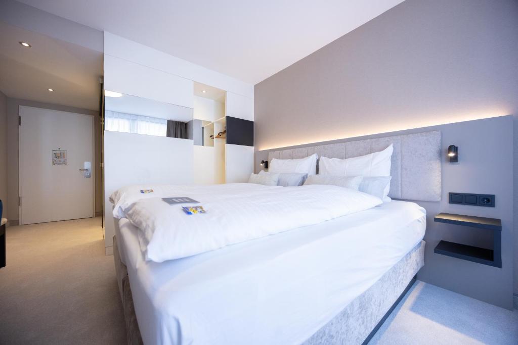Postel nebo postele na pokoji v ubytování Hotel Kronjuwel by BRIGHT - NEU RENOVIERT - NEWLY RENOVATED