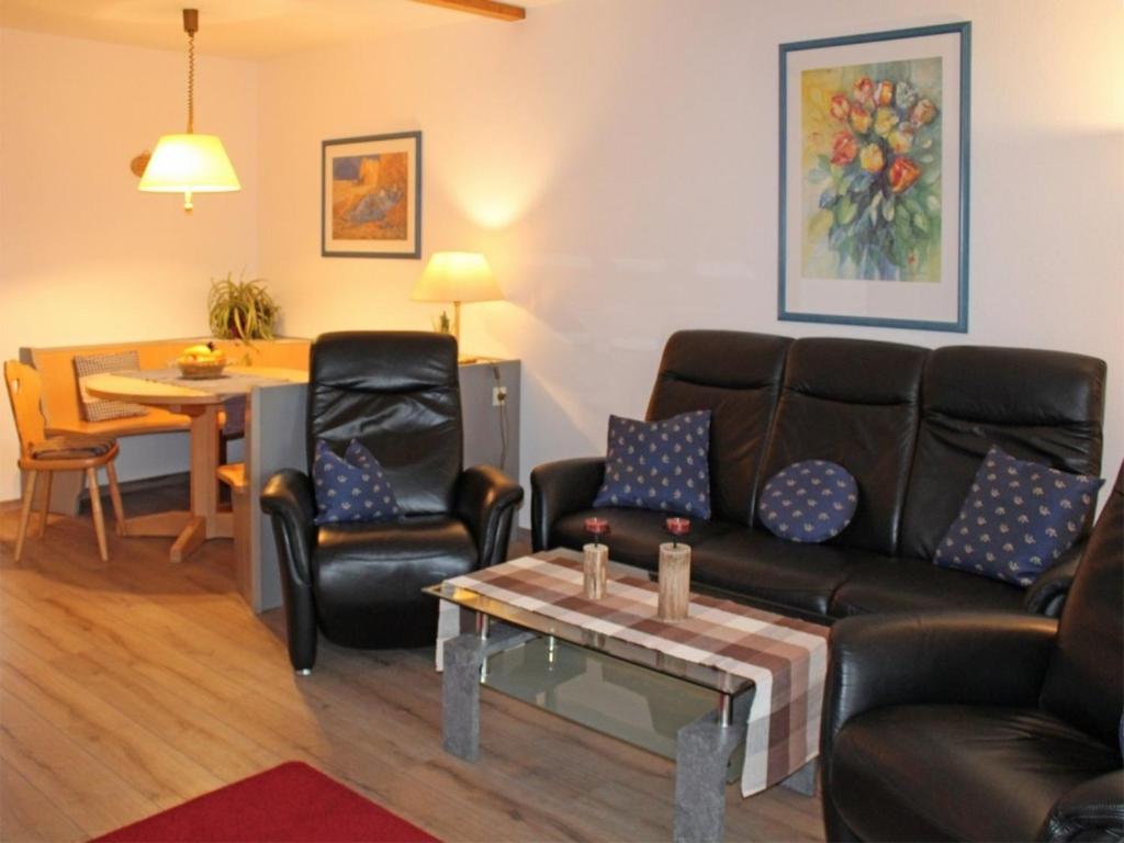 un salon avec un canapé, des chaises et une table dans l'établissement Ferienhaus Nr 28, Kategorie Königscard, Feriendorf Hochbergle, Allgäu, à Lechbruck am See