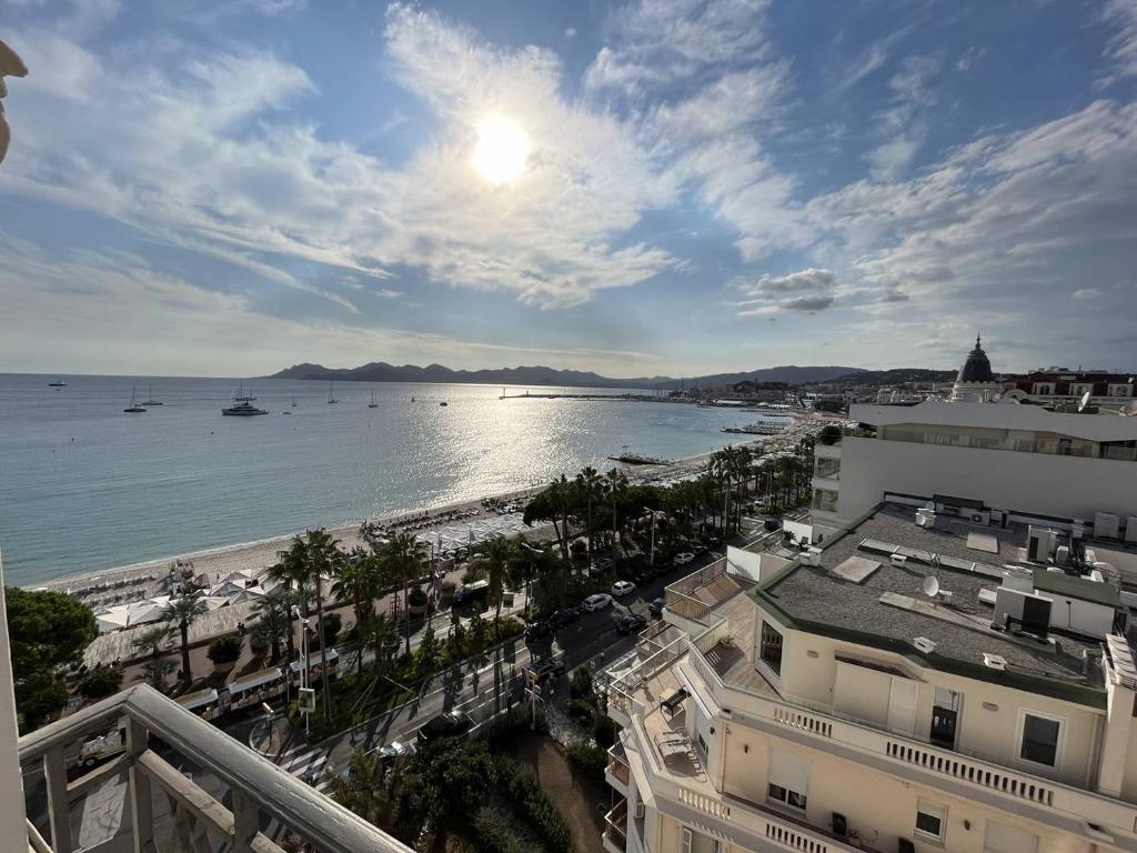 - une vue sur la plage et l'océan avec ses bâtiments dans l'établissement Cannes Croisette - 2 pièces vue mer, à Cannes