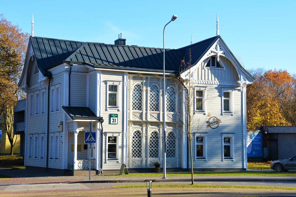 un grand bâtiment blanc avec un toit noir dans l'établissement Dalija, à Druskininkai