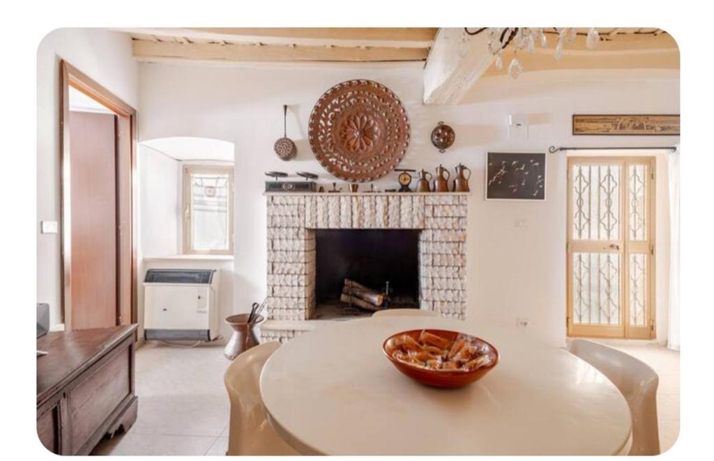 a living room with a table and a fireplace at A casa di Asia nel Borgo Medievale in Poggio Moiano