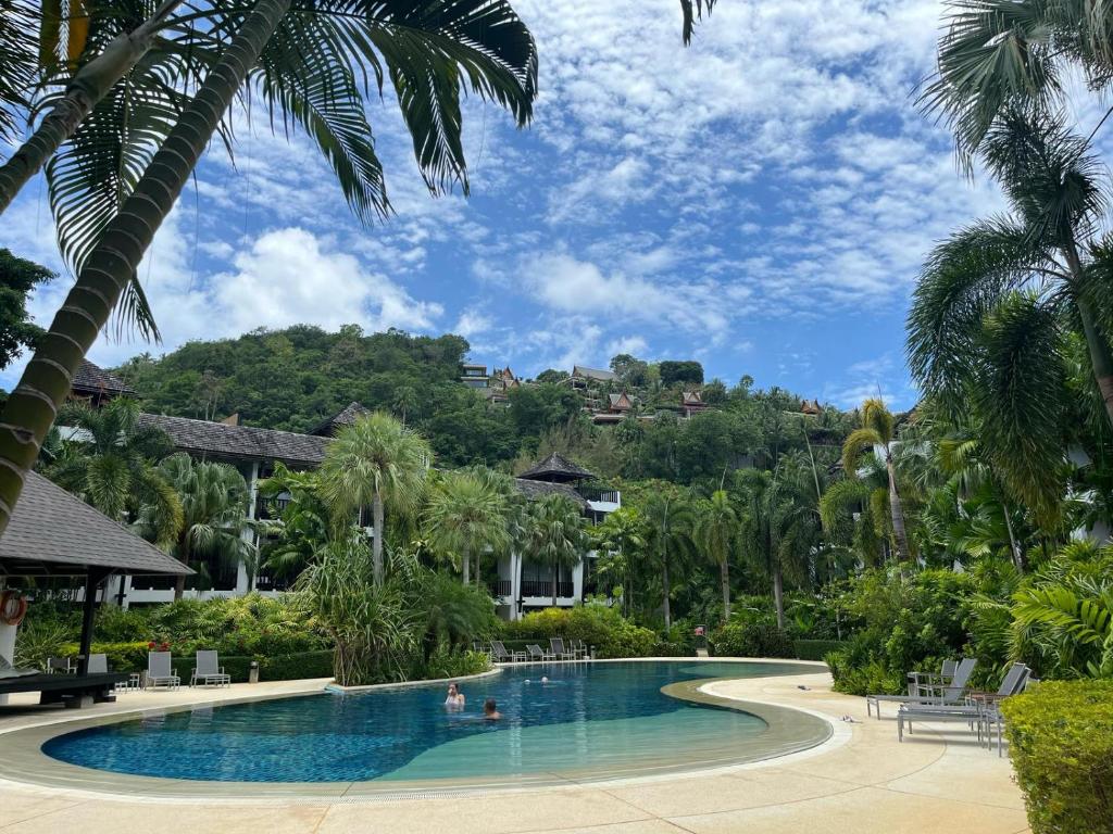 una piscina in un resort con palme di Secret Garden at Bangtao Beach a Surin Beach