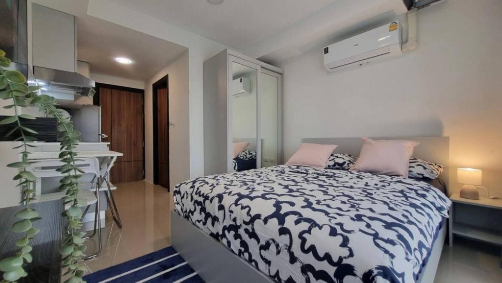 a bedroom with a bed with a black and white comforter at The Urban Tropical Apartments in Mai Khao Beach