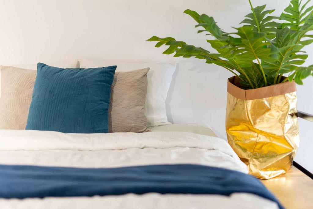 a vase with a plant on a table next to a bed at Studio LOFT12 in Kielce
