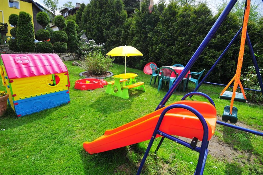 a playground with play equipment in a yard at Willa JANECZKA in Karpacz