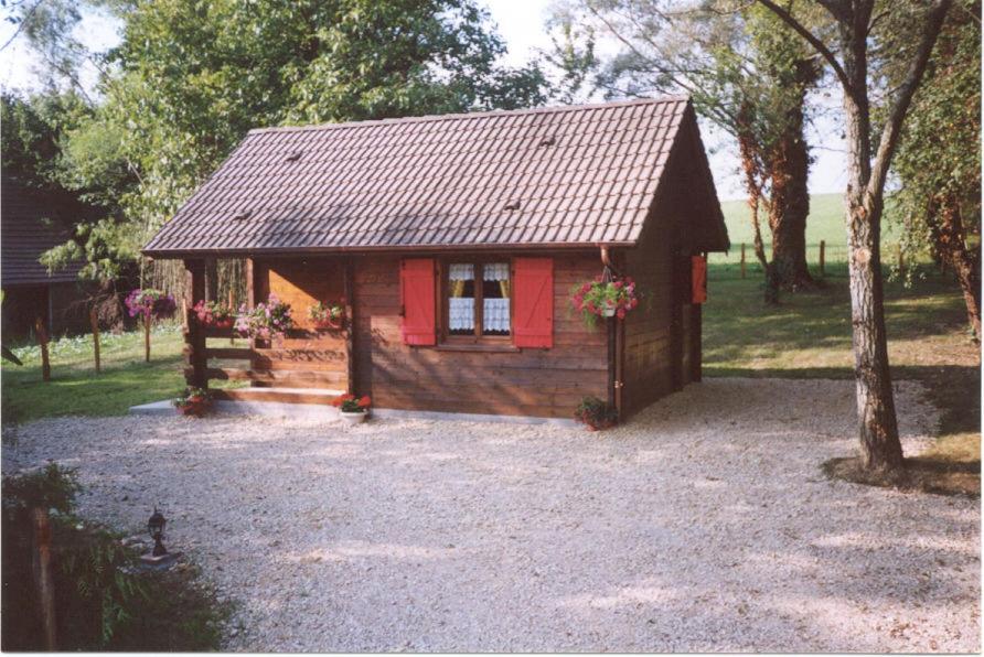 une petite cabane avec une porte rouge et un arbre dans l'établissement Le Chamois, à Le Tartre