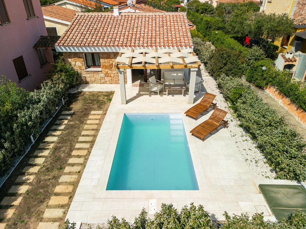 サン・テオドーロにあるAffittaSardegna- Villetta Meravigliaのスイミングプール(椅子付)と家の景色を見渡せます。