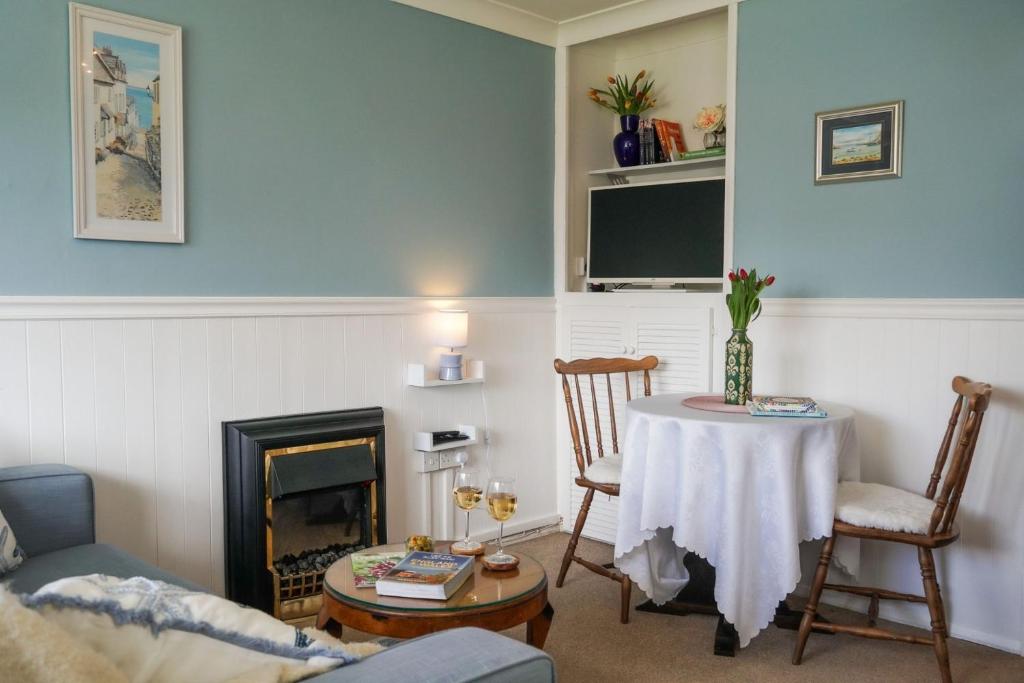 a living room with a table and a fireplace at South Devon - River Dart Views - Free Parking - Pet Friendly in Galmpton-on-the-Dart