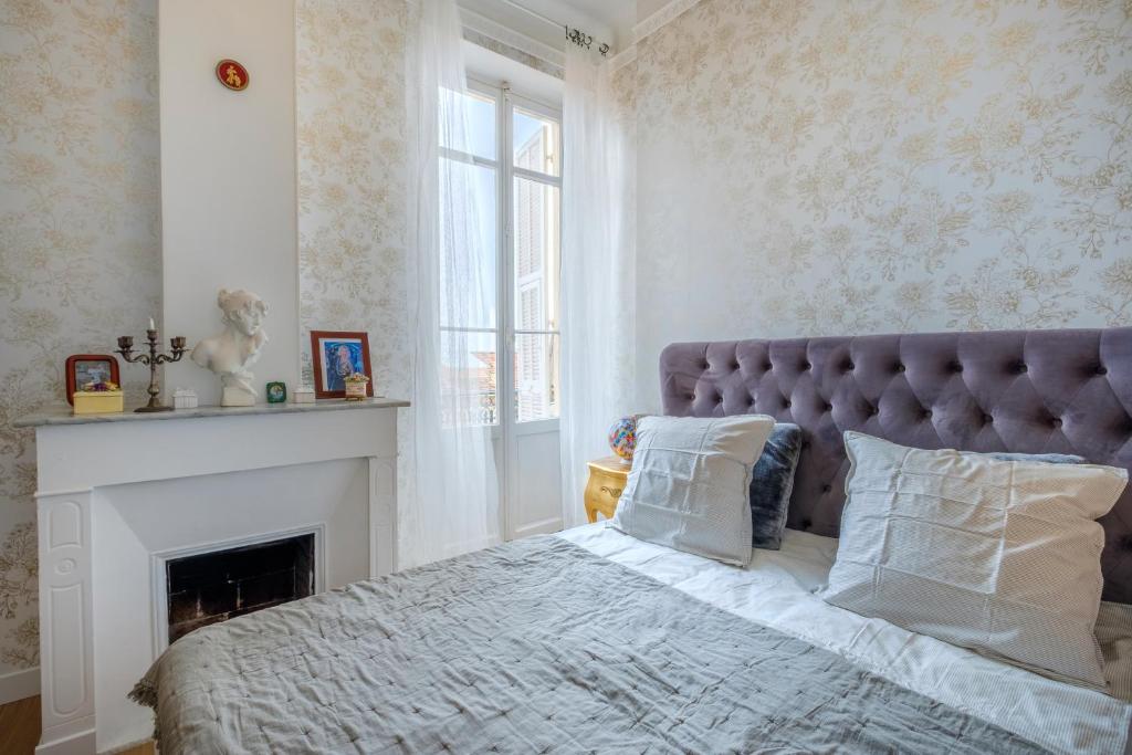 - une chambre avec un grand lit et une cheminée dans l'établissement Joli Appartement proche Monaco, à Beausoleil