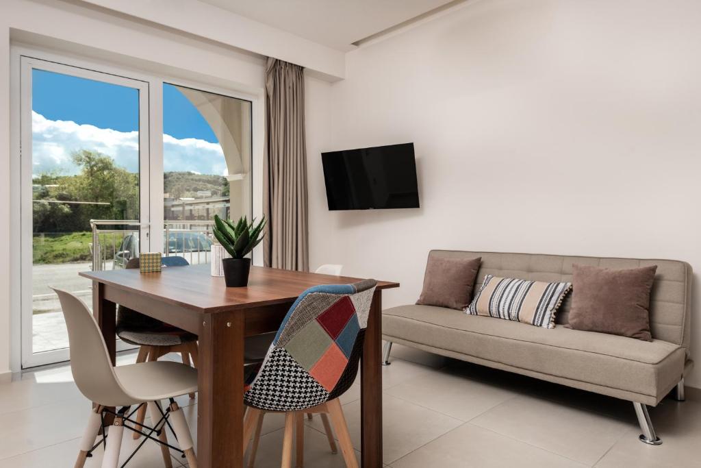 ein Wohnzimmer mit Tisch und Couch in der Unterkunft Katsaros Luxury Apts 5 min walk to beach in Planos