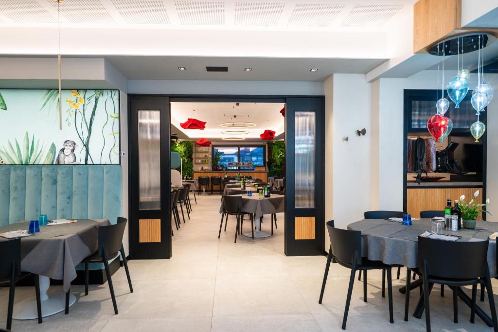 restauracja ze stołami i krzesłami w pokoju w obiekcie Hotel Rolly w mieście Riva del Garda